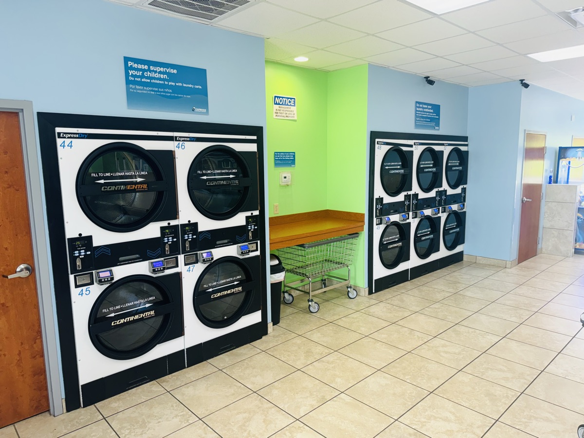 Carritos de ropa y secadoras en Express Laundry Center, donde se procesan los pedidos de recogida