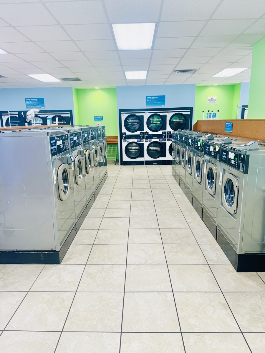 Pasillo entre dos filas de lavadoras de alta eficiencia en Express Laundry Center en Knoxville